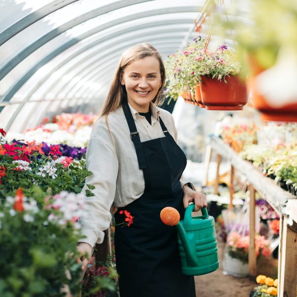 portrait-of-a-young-gardener-woman-watering-flowers-in-a-greenhouse-daily-care-of-plants.jpg