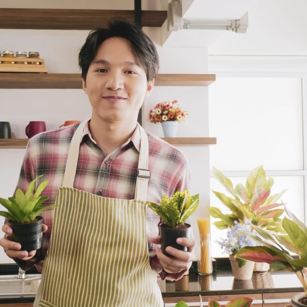 young-gardener-man-holding-flowerpot-in-the-room-.jpg